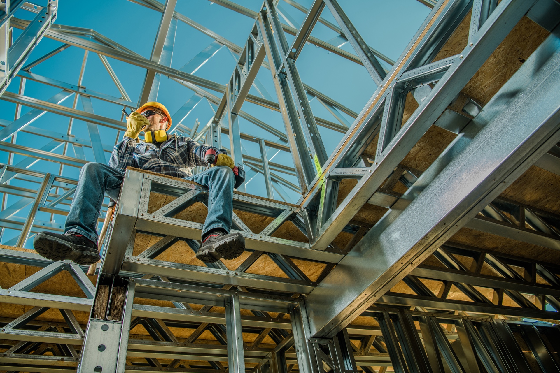 Construction worker assembling cold-formed steel wall framing on site
