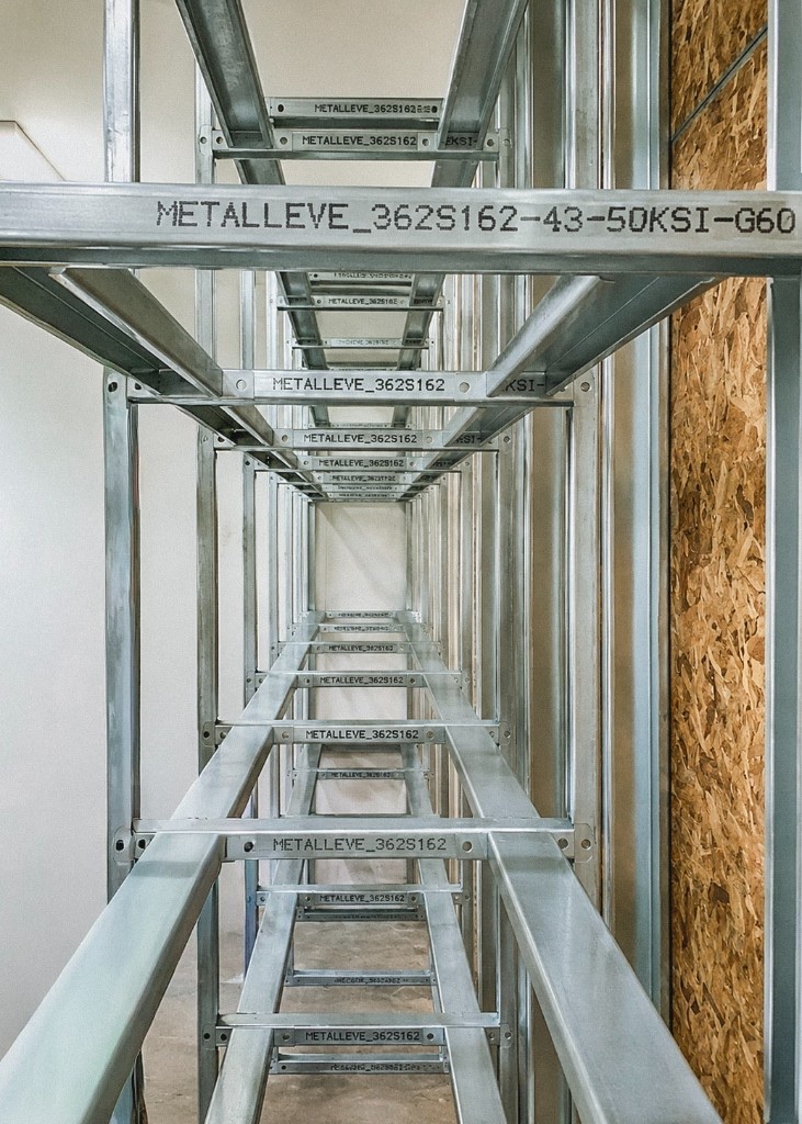 Cold-formed steel wall panel showing track, vertical studs, header, and jamb studs around a window opening